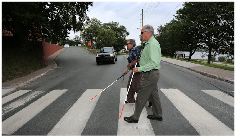 Men with canes crossing at a cross walk